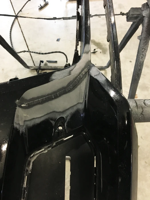 Carrosserie de berline en cabine de peinture professionnelle, masquée avec du papier kraft et ruban adhésif de masquage jaune