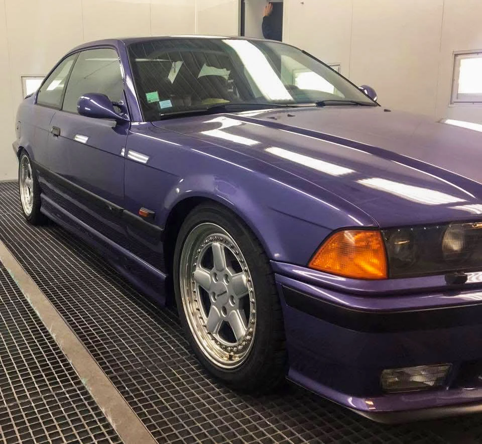 Carrosserie de berline en cabine de peinture professionnelle, masquée avec du papier kraft et ruban adhésif de masquage jaune