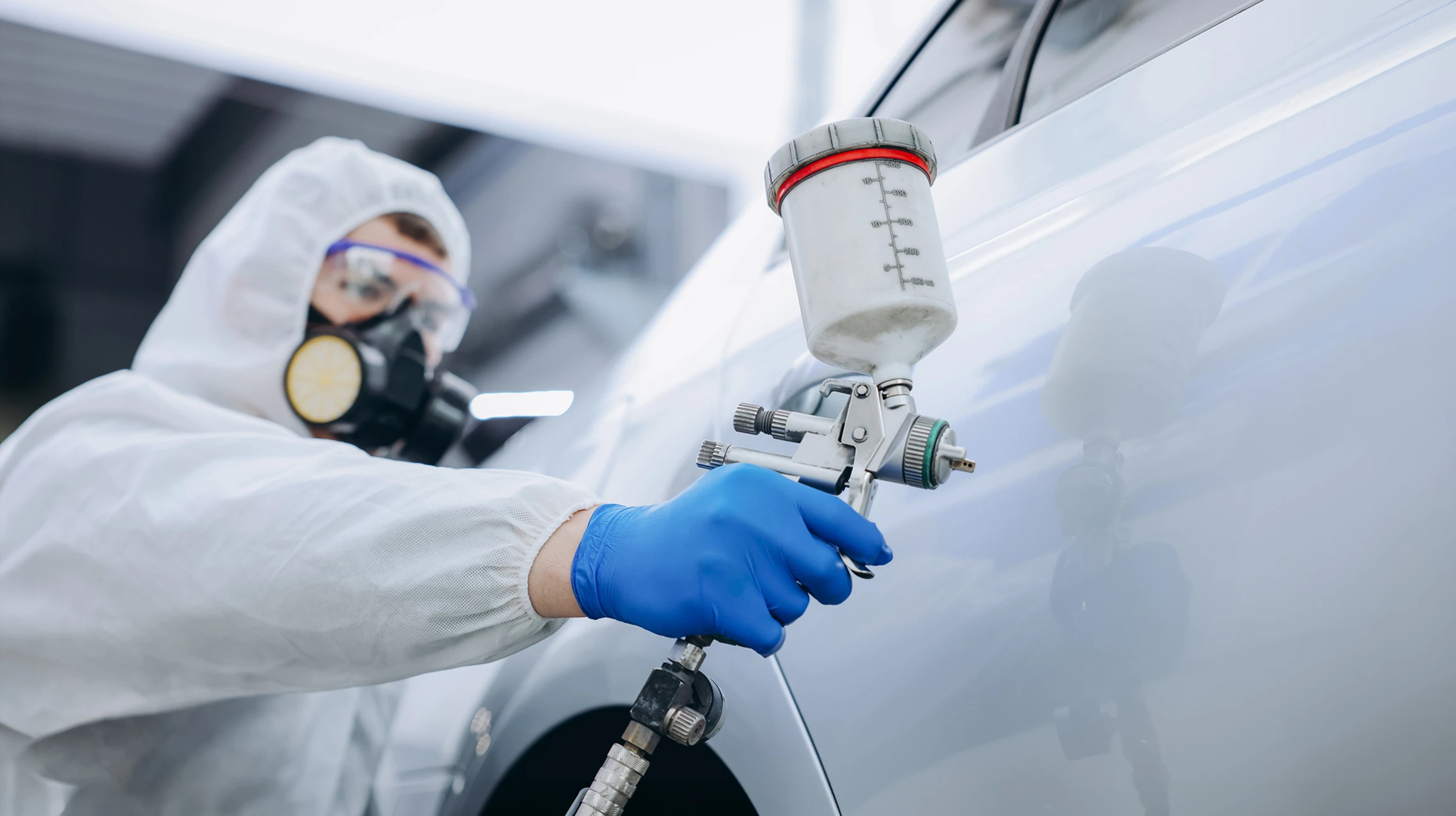 Atelier de réparation automobile avec mécaniciens travaillant sur véhicules surélevés